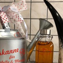 Gießkanne mit Aufkleber als Geschenk
